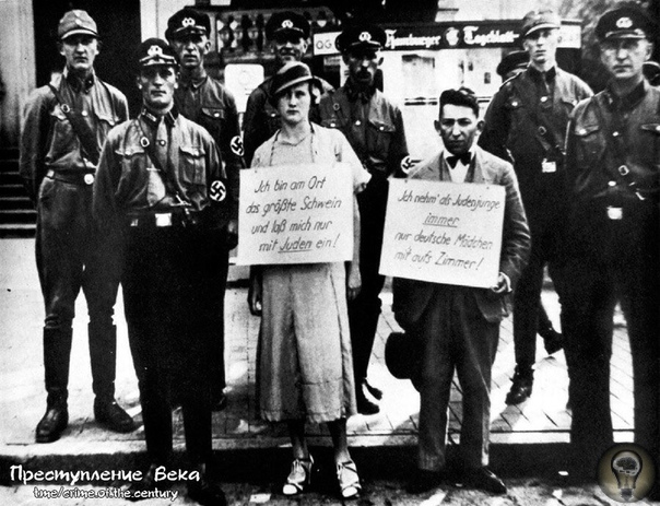 Штурмовики позируют вместе с нарушителями закона о расовой чистоте. На шее женщины плакат «Я большая свинья и я даю только евреям!».На шее мужчины плакат «Я еврей, только что пригласивший