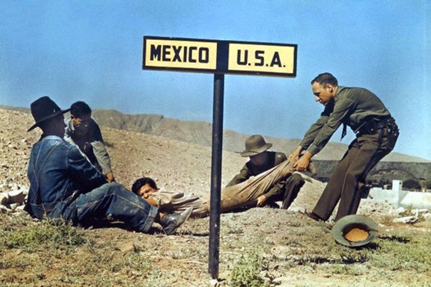 Два американских пограничника пытаются удержать беглеца, который уже успел частично пересечь границу с Мексикой (Эль-Пасо, штат Техас, США, 1939 года